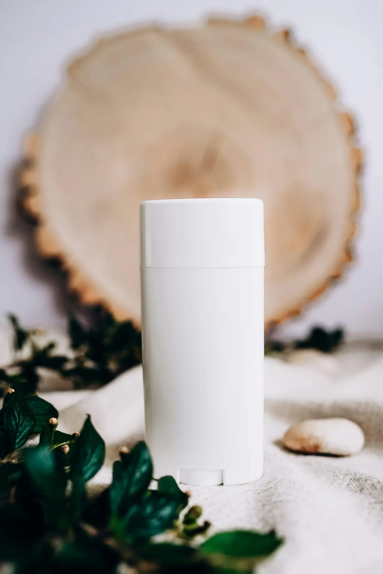 White scent diffuser surrounded by fresh leaves, enhancing natural ambiance.